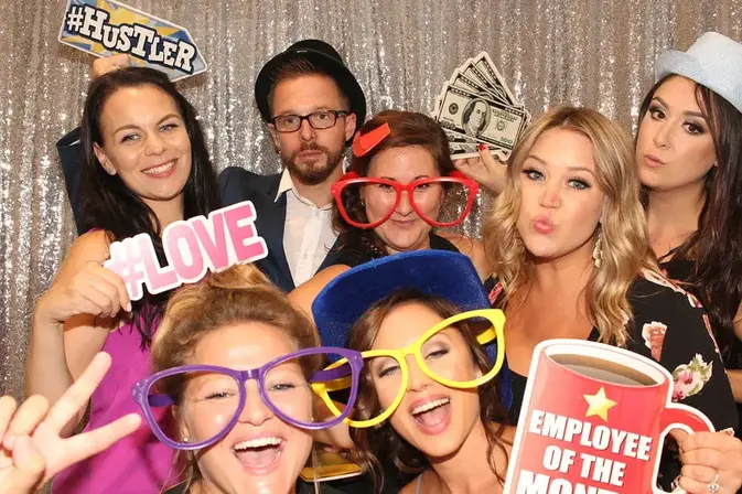 Wedding guests holding fun props in a photo booth in Vaughan