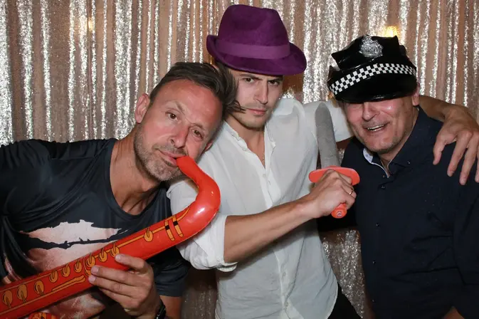 Colleagues with props in a photo booth at a corporate holiday party