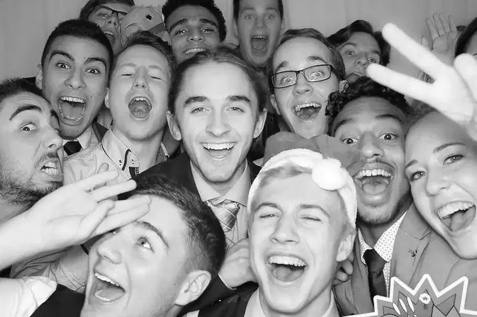 Teens having fun in a photo booth at a sweet 16 party